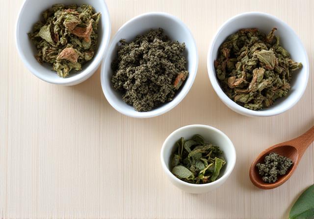 Loose leaf tea leaves in ceramic bowls with a wooden spoon